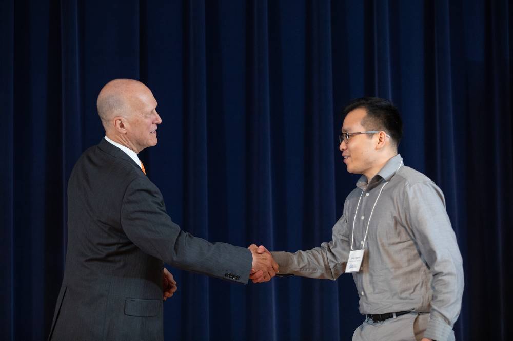 James Nguyen shaking hands with Dr. Potteiger.
